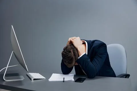 Handsome businessman problems at work sitting at a desk in front of a computer Stock Photos
