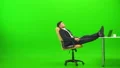 The handsome businessman relaxing at the table on the green background 4k or 4k+ Resolution
