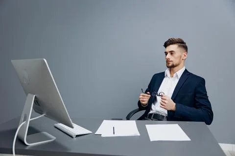 Handsome businessman sitting at a desk in front of a computer isolated Stock Photos