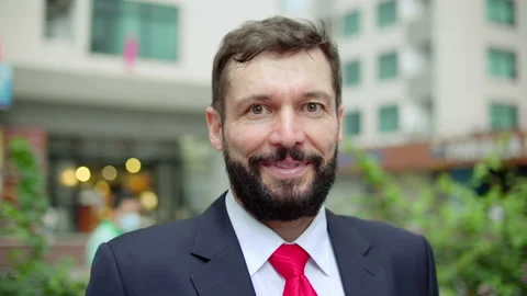 Handsome businessman smiling looking into the camera outside modern commercial Vídeos de archivo 187795536