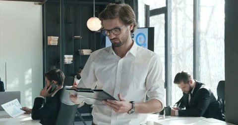 Handsome Businessman Standing in front of Camera while Taking on his Eyeglasses Видео 124286774