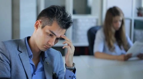 Handsome businessman is thinking over idea sitting in office Stock Footage 65795060