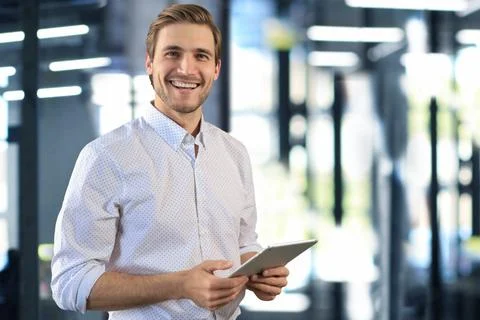 Handsome businessman using his tablet in the office. Stock Photos