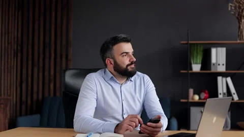 Handsome businessman using smartphone sitting in home office. Happy smiling Stock Footage 162467885