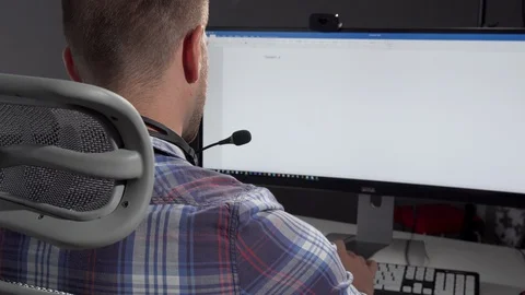 Handsome call center operator smiling to the camera after typing on his computer 動画素材 115535882