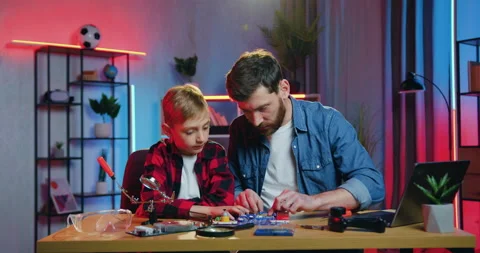 Handsome caring confident positive bearded father helping to assemble the small Stock Footage 155652201