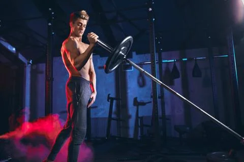 Handsome caucasian bodybuilder man doing cross fit exercise with barbell in gym Stock-Fotos