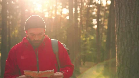 Handsome Caucasian man in hat walks in woods on sunny day enjoying nature and Stock Footage 147065692