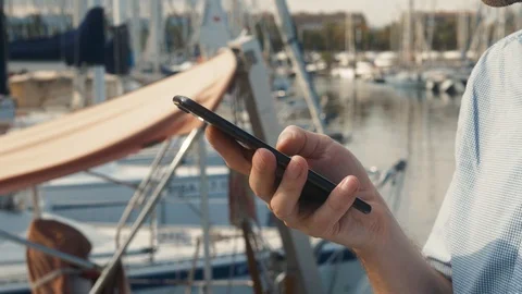 Handsome Caucasian man smiles while using cell phone as he leans against railing Stock Footage 118526864