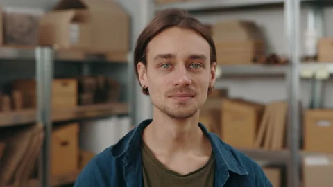 Handsome caucasian man standing at the table and posing with parcels at the Stock Footage 169340983