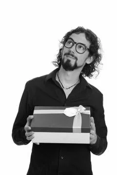 Handsome Caucasian man thinking while holding git box ready for Valentine's day Stockfoto's