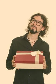 Handsome Caucasian man thinking while holding git box ready for Valentine's day 写真素材