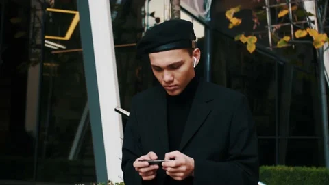 Handsome caucasian man using a smartphone for playing games online outside Stock Footage 143355689
