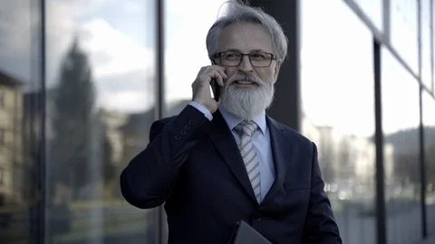 Handsome  caucasian senior CEO using a smartphone and smart tablet Stock Footage 109135372