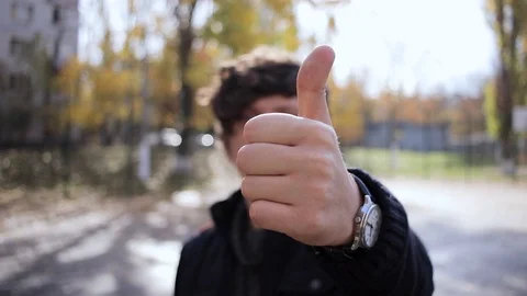 Handsome cheeky young guy smiles in the park Video stock 125088264