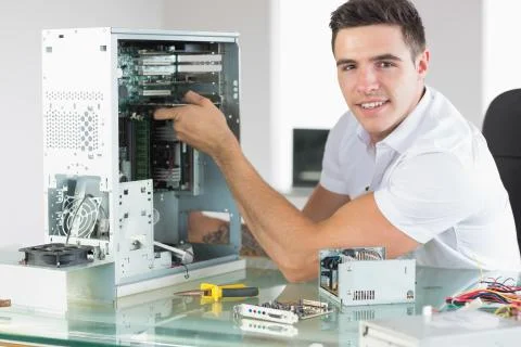 Handsome cheerful computer engineer working at open computer Stock Photos