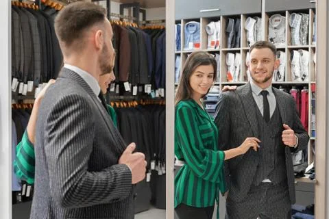 Handsome client in suit looking at mirror of boutique. Stock Photos