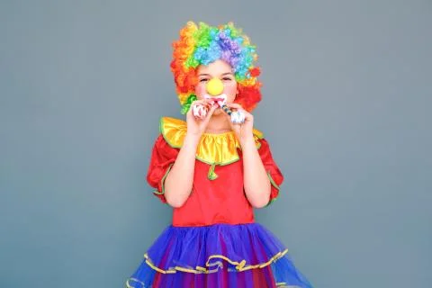 Handsome clown girl holding two pipe or birthday whistle Stock Photos