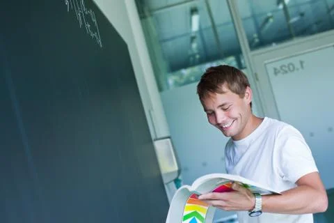 Handsome college student solving a math problem during math clas Stock Photos