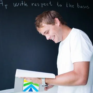 Handsome college student solving a math problem during math clas Stock Photos