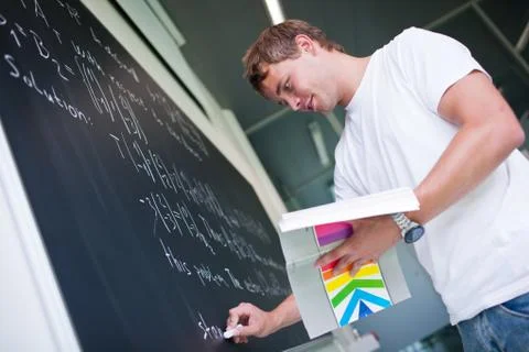 Handsome college student solving a math problem during math clas Stock Photos