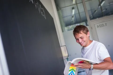 Handsome college student solving a math problem during math class in front of Stock Photos
