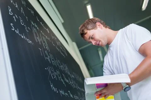Handsome college student solving a math problem during math class  Stock Photos