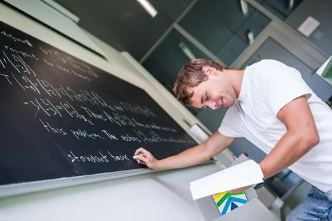 Handsome college student solving a math problem during math class Stock Photos