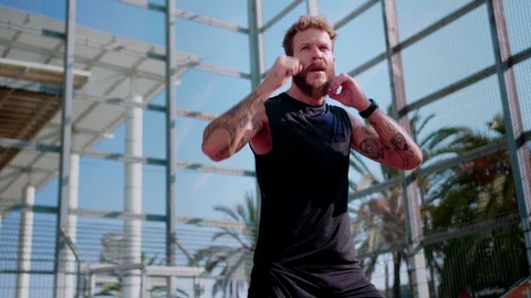 Handsome concentrated guy does exercising outdoor in urban sport ground area Stock Footage 116741396