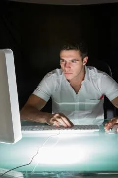 Handsome concentrating computer engineer working at night Stock Photos
