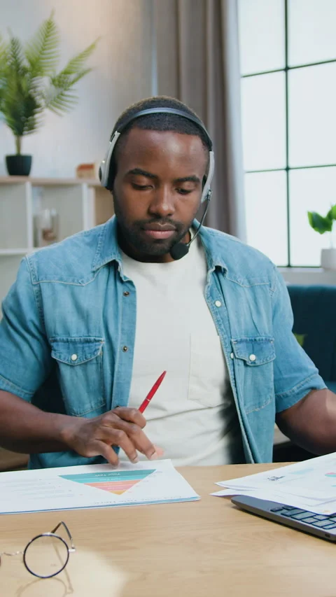 Handsome confident experienced bearded african man in headset sitting in front o Stock Footage 325315726
