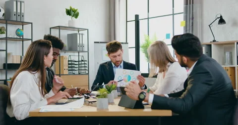 Handsome confident experienced bearded main manager explaining report with chart Stock Footage 159555140