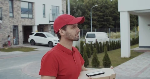 Handsome courier searching client house carrying pizza boxes outdoor. Modern Stock-Footage 114941253