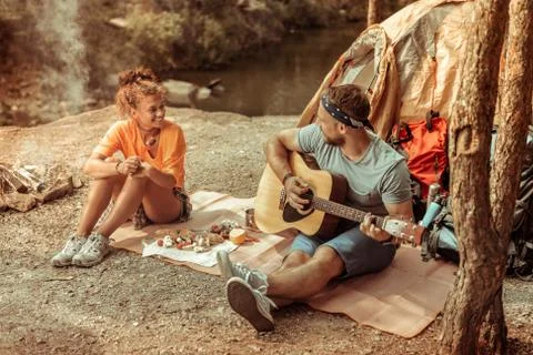 Handsome creative young man playing guitar songs Stock Photos