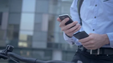 Handsome cyclist checking his phone on morning commute Video stock 74637737