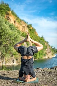 Handsome dark haired man with beard practicing yoga. Young man standing on hi Stock Photos