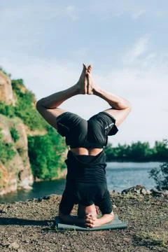 Handsome dark haired man with beard practicing yoga. Young man standing on hi Foto stock