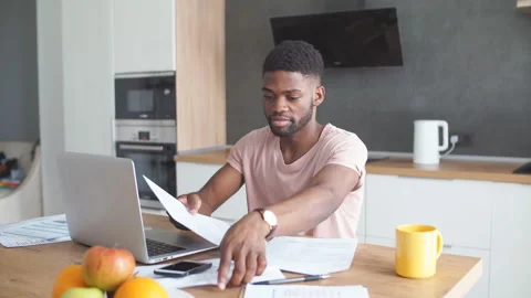 Handsome dark-skinned man having serious facial expression while paying online Stock Footage 101029147