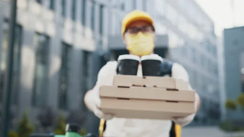 Handsome delivery man in protective face mask holding stack of pizza cardboard Stock Footage 172041005