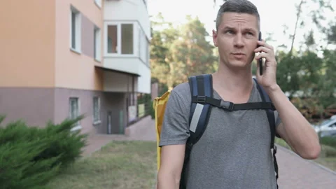 Handsome delivery service worker is calling the customer. Stock Footage 138862042