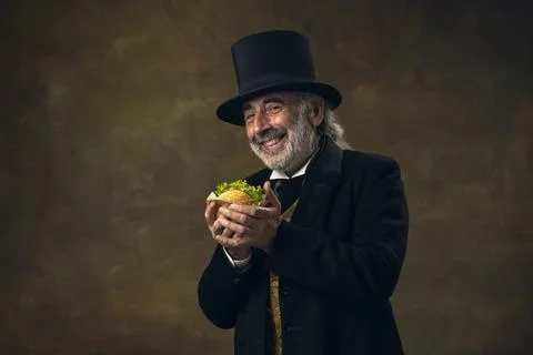 Handsome elderly gray-haired man, gentleman, aristocrat or actor eating fast Stock Photos