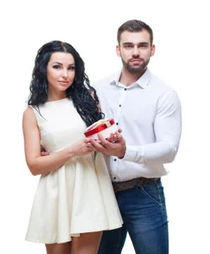 Handsome elegant guy is presenting a heart shaped gift to his beautiful Stock Photos