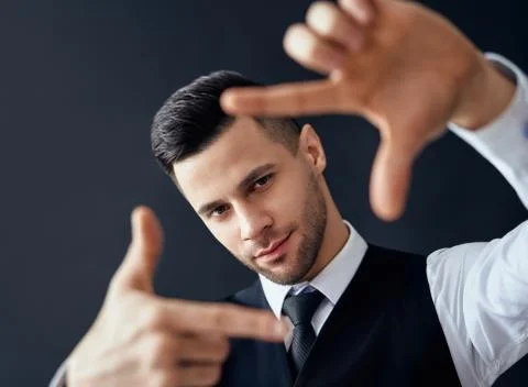 Handsome elegant man looking through a finger frame Stock-Fotos