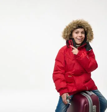 Handsome elementary aged boy dressed in bright red parka holding airplane toy Stock Photos