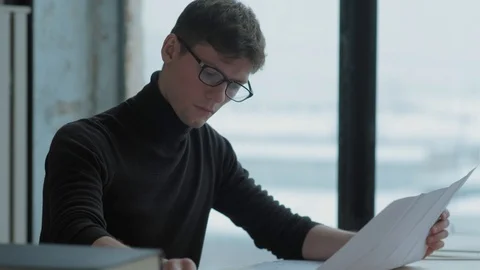 Handsome engineer in glasses works with project, takes a drawing Stock-Footage 125011344