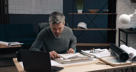 Handsome Engineer of Middle age looking at Model of Future Building and Stock Footage 126245598