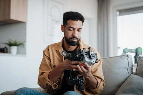 Handsome engineer student working on robot project at home. Foto stock