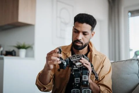 Handsome engineer student working on robot project at home. Foto stock