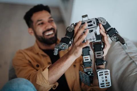 Handsome engineer student working on robot project at home. Foto stock