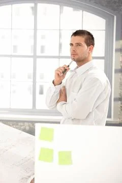 Handsome engineer working in office Handsome young engineer working in bri... Stock Photos